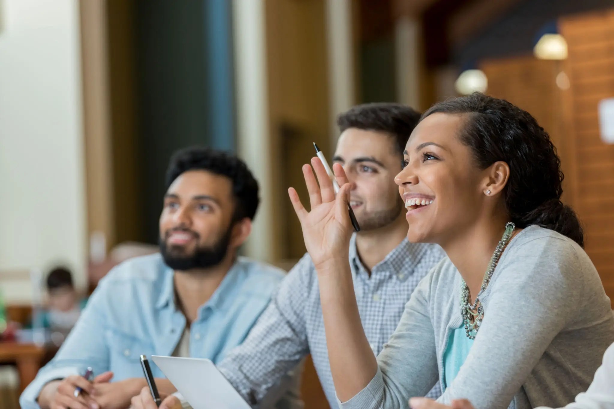 Three colleagues engaged in a lively discussion during a meeting.