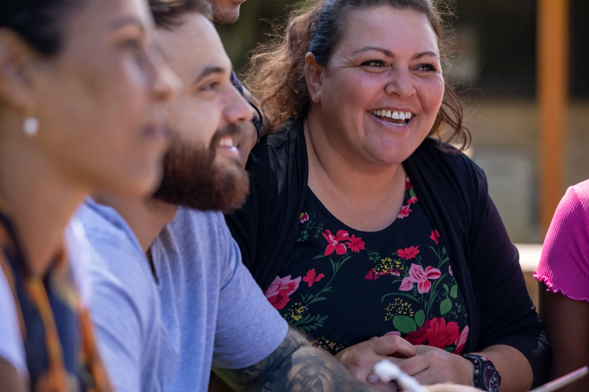 Three people sitting together and smiling joyfully.