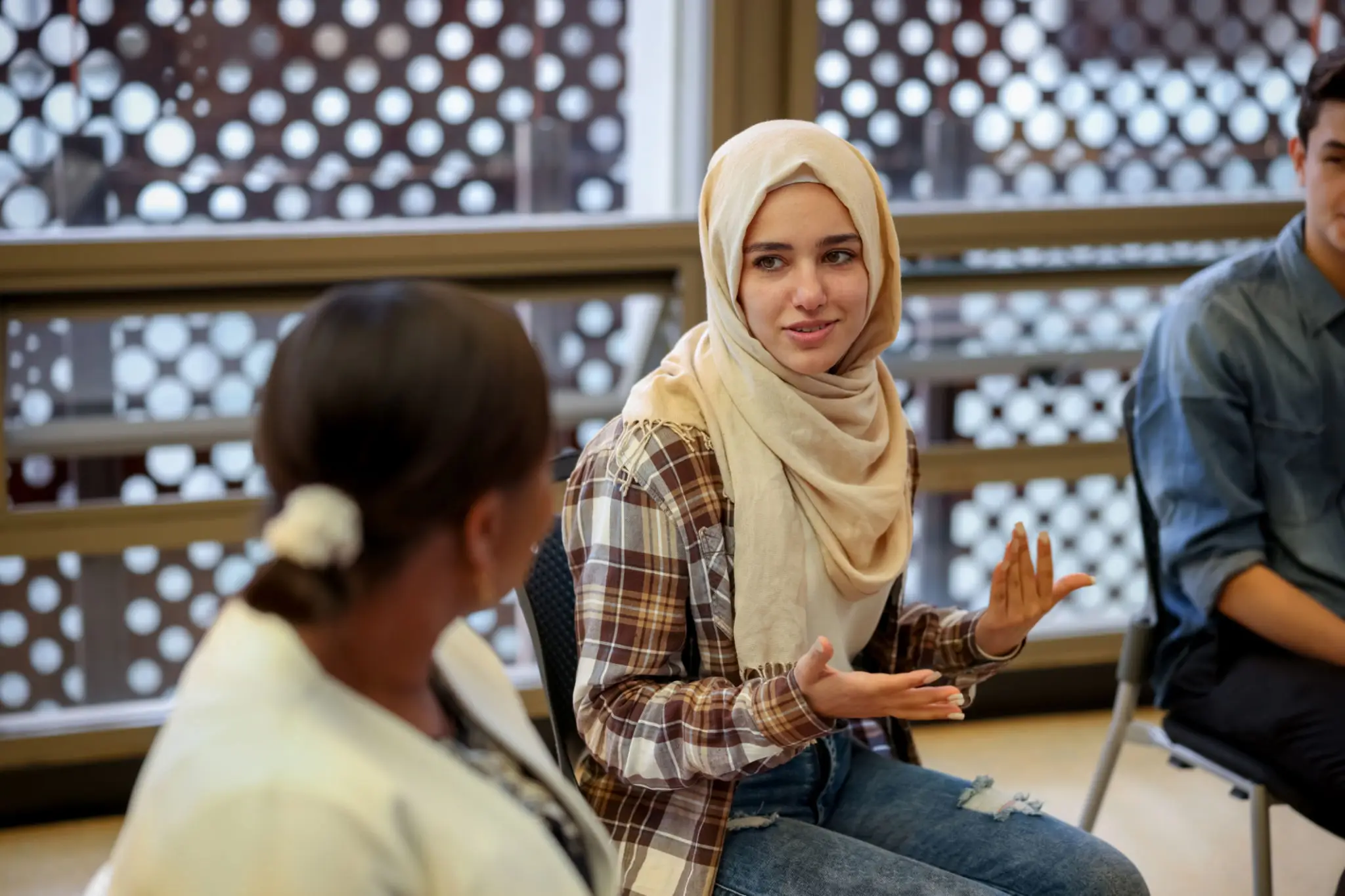 Two women engaged in a thoughtful conversation indoors.